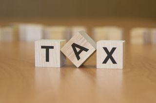 the word tax on three blocks with the A tilted